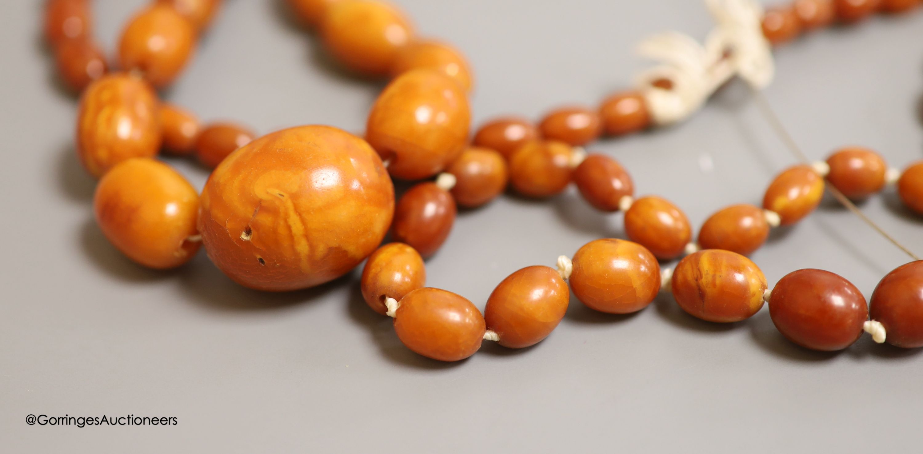 Nine assorted single strand amber bead necklaces, longest approximately 46cm, gross weight 173 grams and one simulated amber bead necklace.